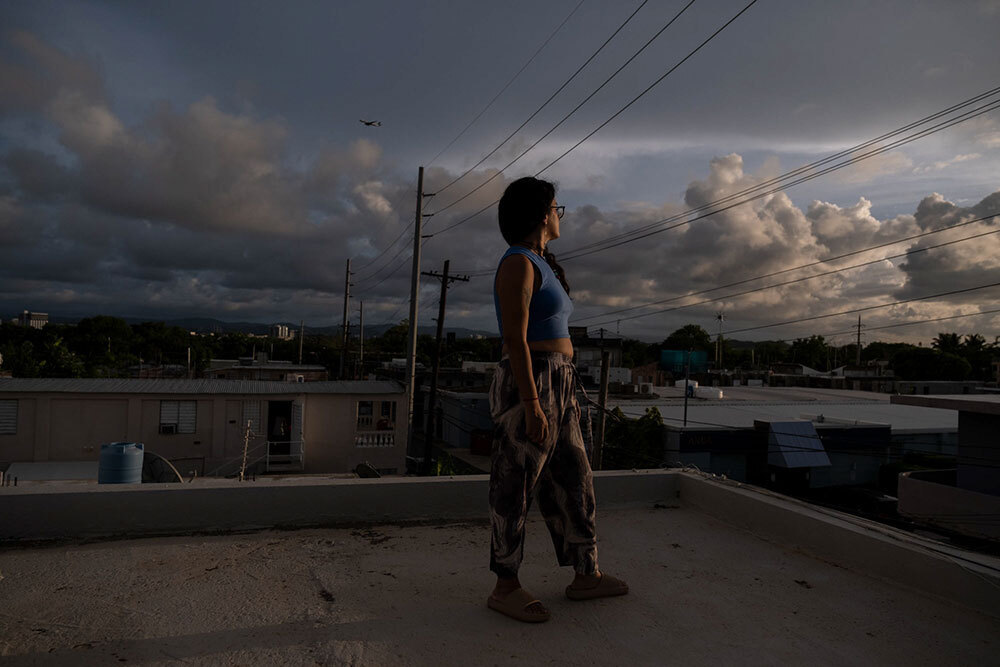 A woman looks out off of a rooftop