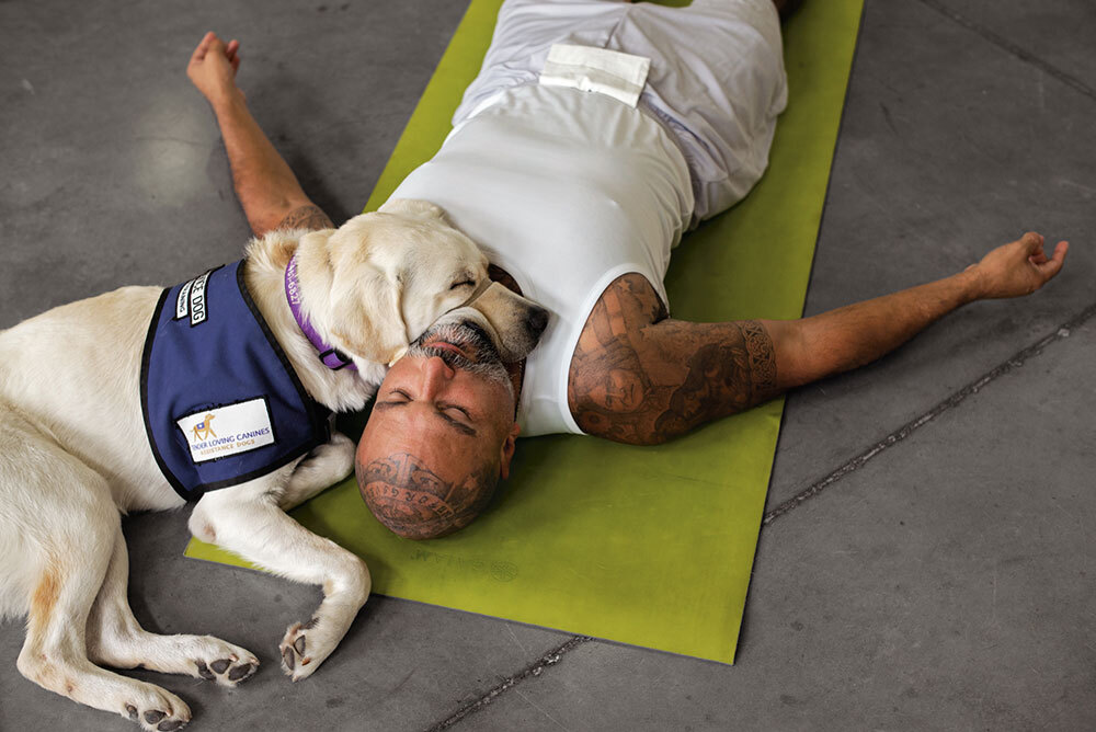 A man and a dog laying down on a yoga mat