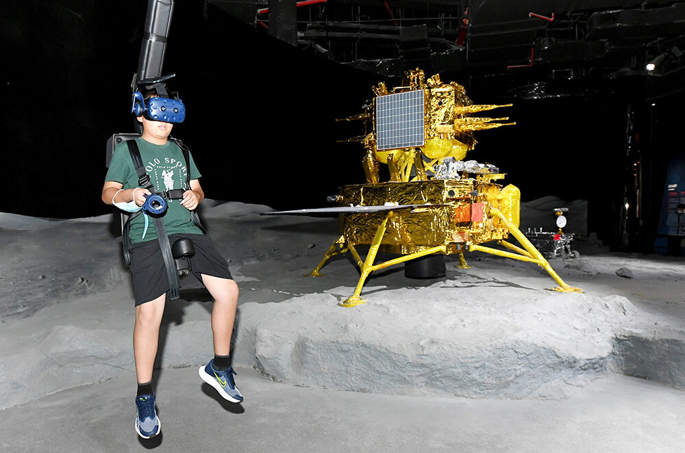 A visitor wearing VR headset experiences walking on the moon at the Shanghai Astronomy Museum on its opening day on July 17, 2021 in Shanghai, China. ​