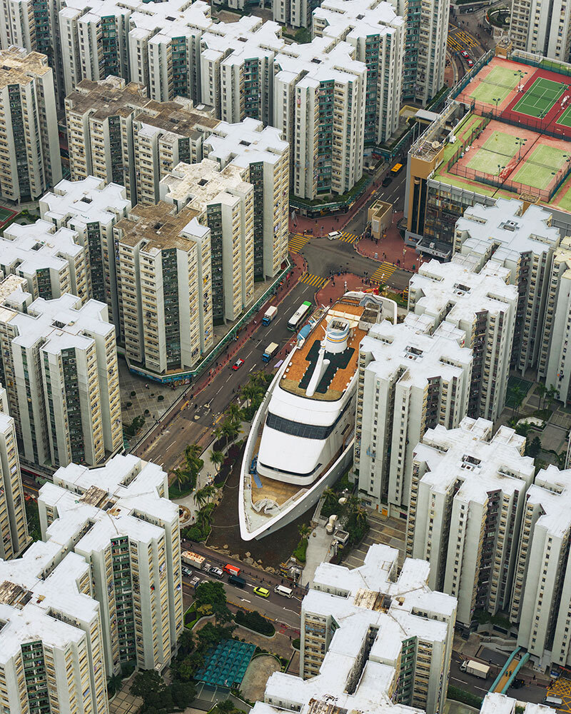 A photo of a large boat sitting on land between tall buildings