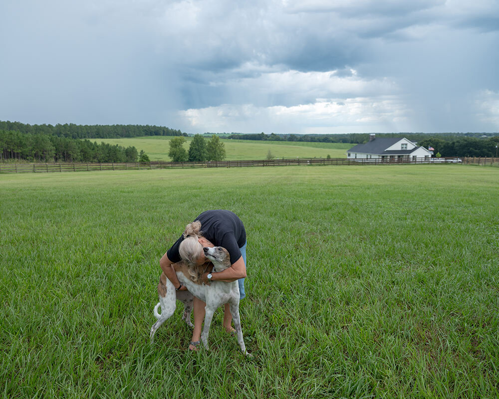 Sharon Dippel hugs a retired greyhound that she adopted in Florida. With fewer shelter and rescue dogs available, some dog owners may want to consider buying dogs from responsible breeders who prioritize health and temperament.