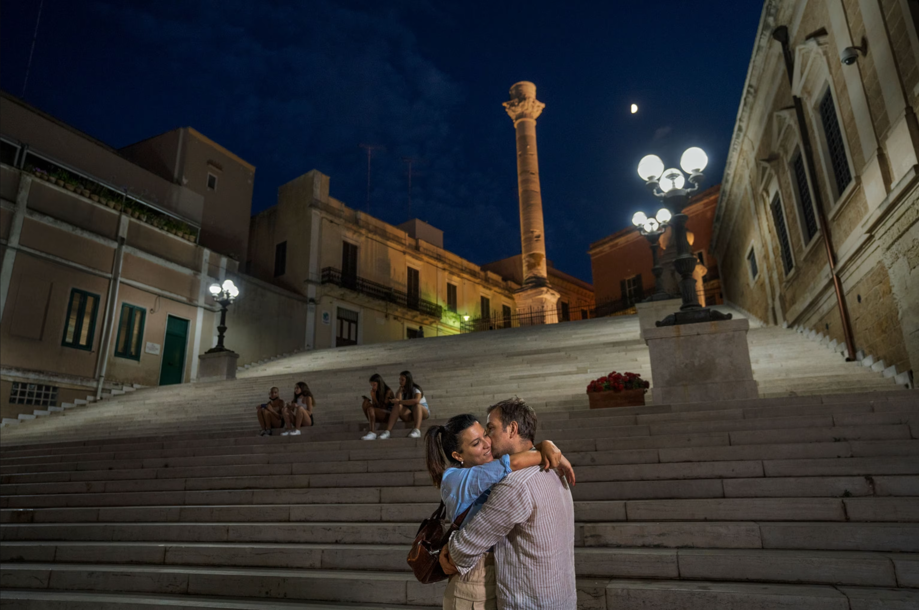 A couple embraces at the Port of Brindisi in Italy. 