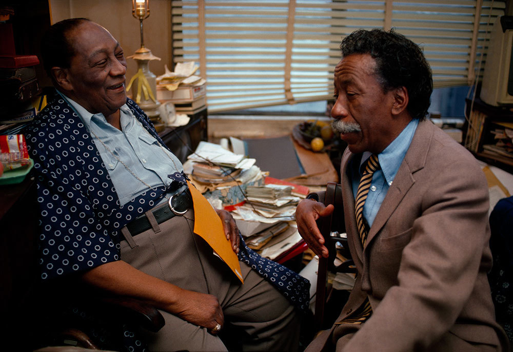 A picture of two men chatting in a room