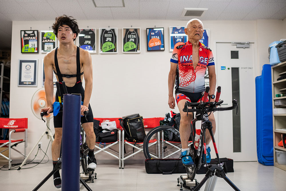 A photo of a young and an old person on stationary bikes