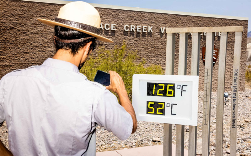 A park ranger takes a photo of a thermometer at California’s Death Valley National Park in 2021. Metric was officially declared America’s preferred system of measurement in 1975, but the U.S. public has been slow to embrace it.