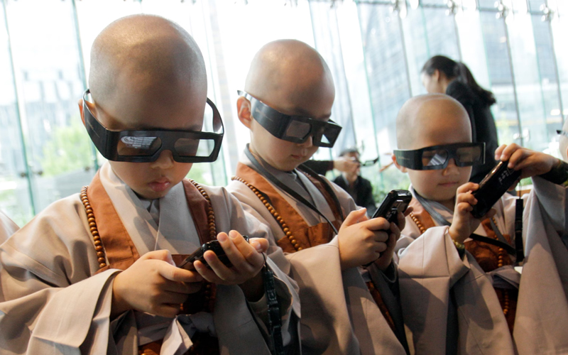 Young Korean boys in Seoul participate in a Buddhist training camp experience and use 3D glasses and smartphones to learn about their faith. 