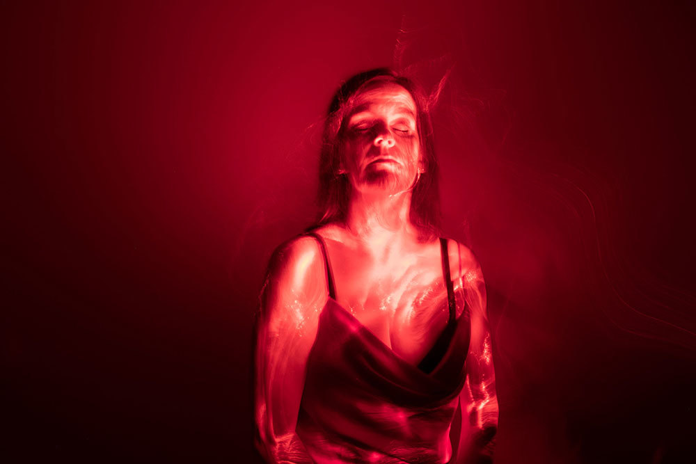 A picture of a woman with bright red light on her