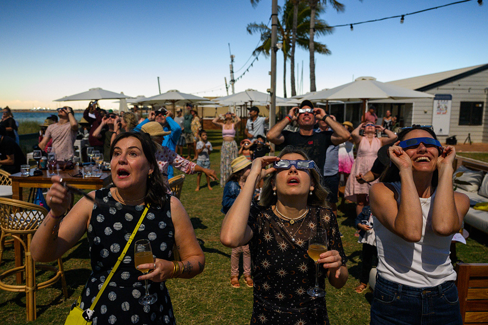 A crowd of onlookers watch a total solar eclipse in Exmouth, Australia, on April 20, 2023