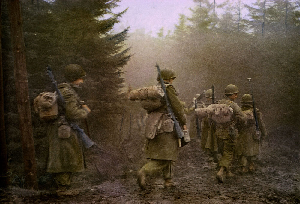 Members of Airborne Division moving through the forest, Ardennes-Alsace Campaign, Battle of the Bulge.