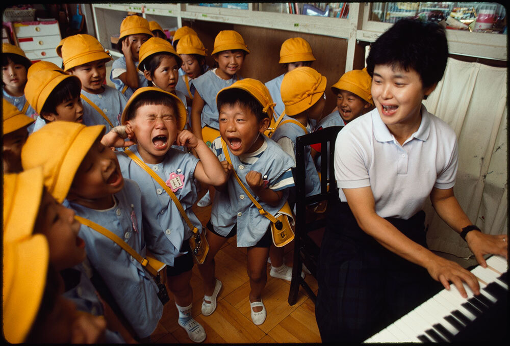 A teacher plays the piano for her kindergarten class