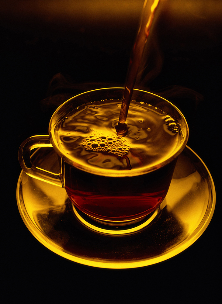 Close view of coffee being poured into a glass cup