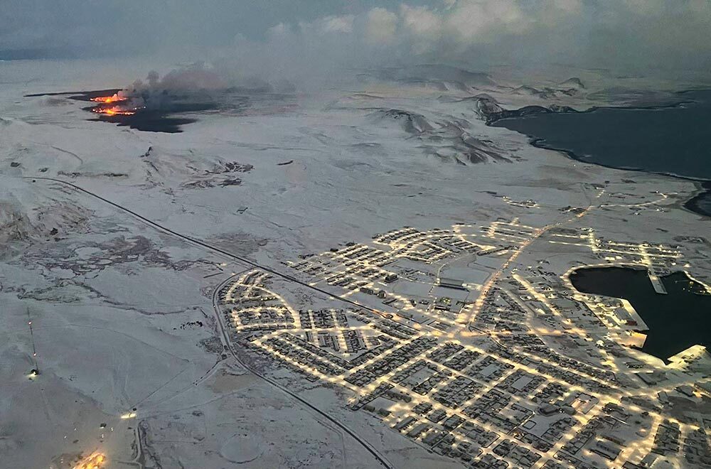 An aerial view of the evacuated town of Grindavik, with smoke and lava seen emerging from a nearby fissure.