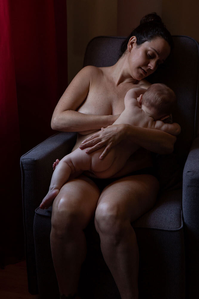 a baby struggles to get away from her mother's breast