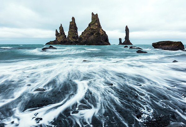 According to Icelandic folklore, the basalt rock formations off the coast of Vik were once trolls.