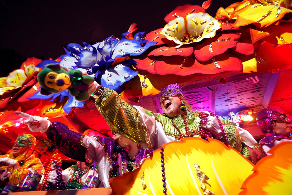 On Mardi Gras, members of the Krewe of Orpheus toss trinkets to onlookers as they parade through New Orleans.