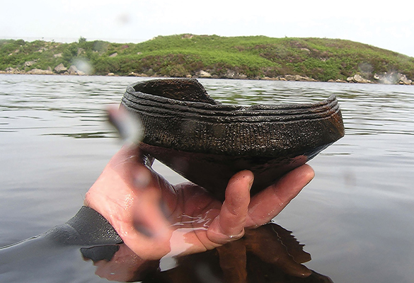 A diver holds a Neolithic (ca. 3,500 B.C) Ustan vessel found near a crannog (artificial island) in Loch Arnish, Scotland.