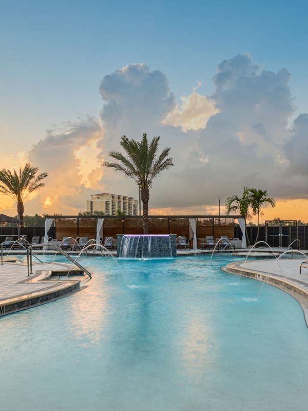 A swimming pool flanked by palm trees at a hotel participating in Marriott Bonvoy.
