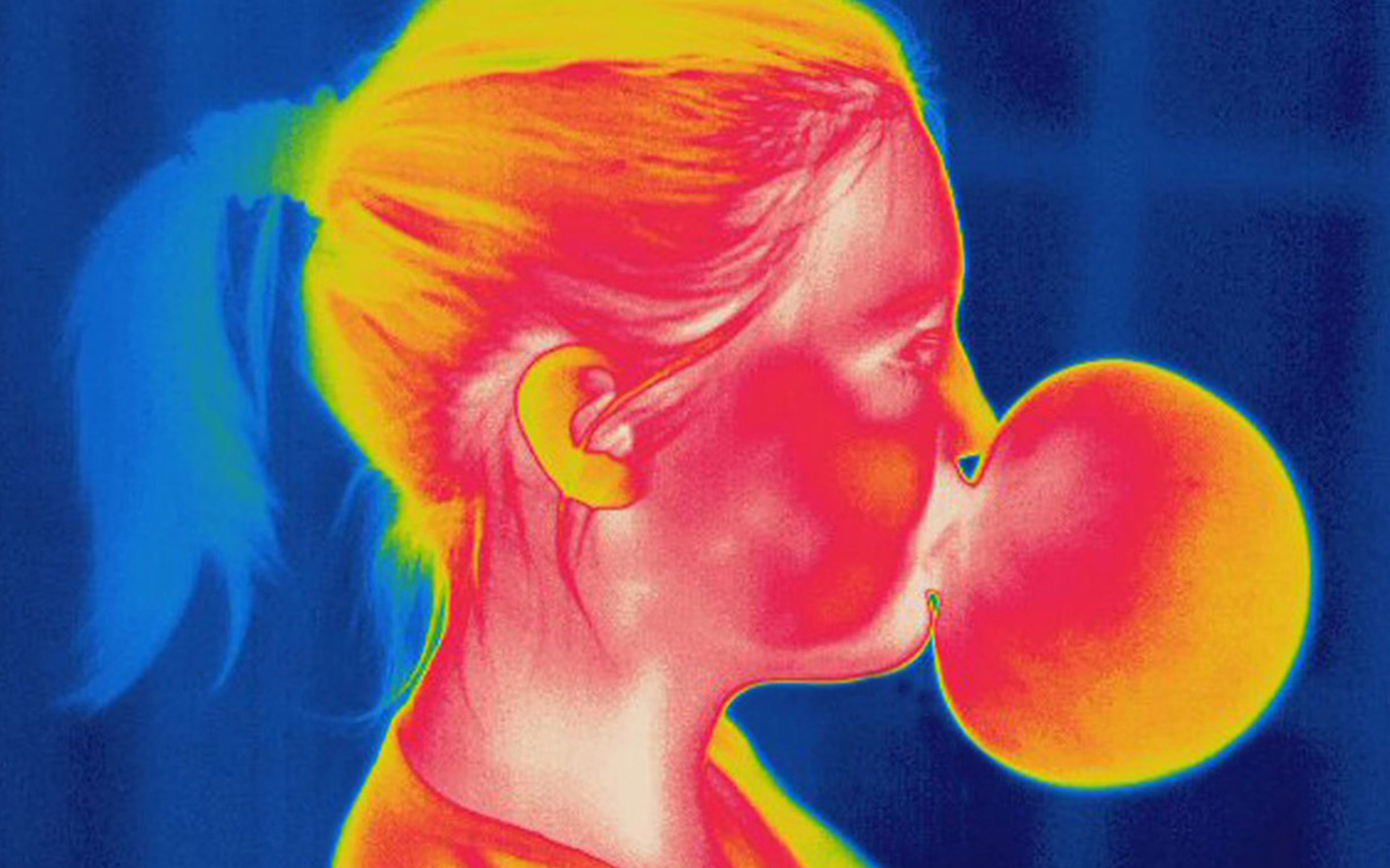 An image of a young girl blowing a bubble.