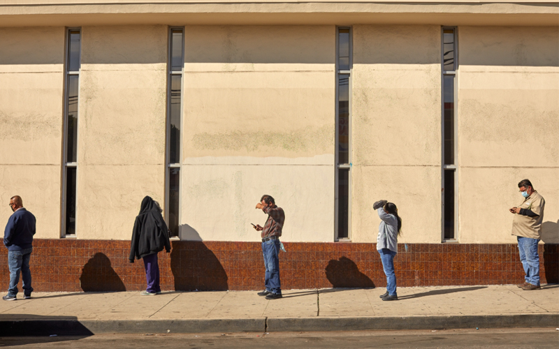 People wait in line without shade for unemployment payments outside a bank in Boyle Heights, Los Angeles.