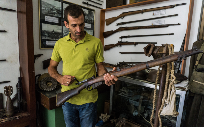 Stelios Tripalitakis holds an original rifle used during the Battle of Crete, part of his extensive collection dedicated to preserving the island’s wartime history and resistance.