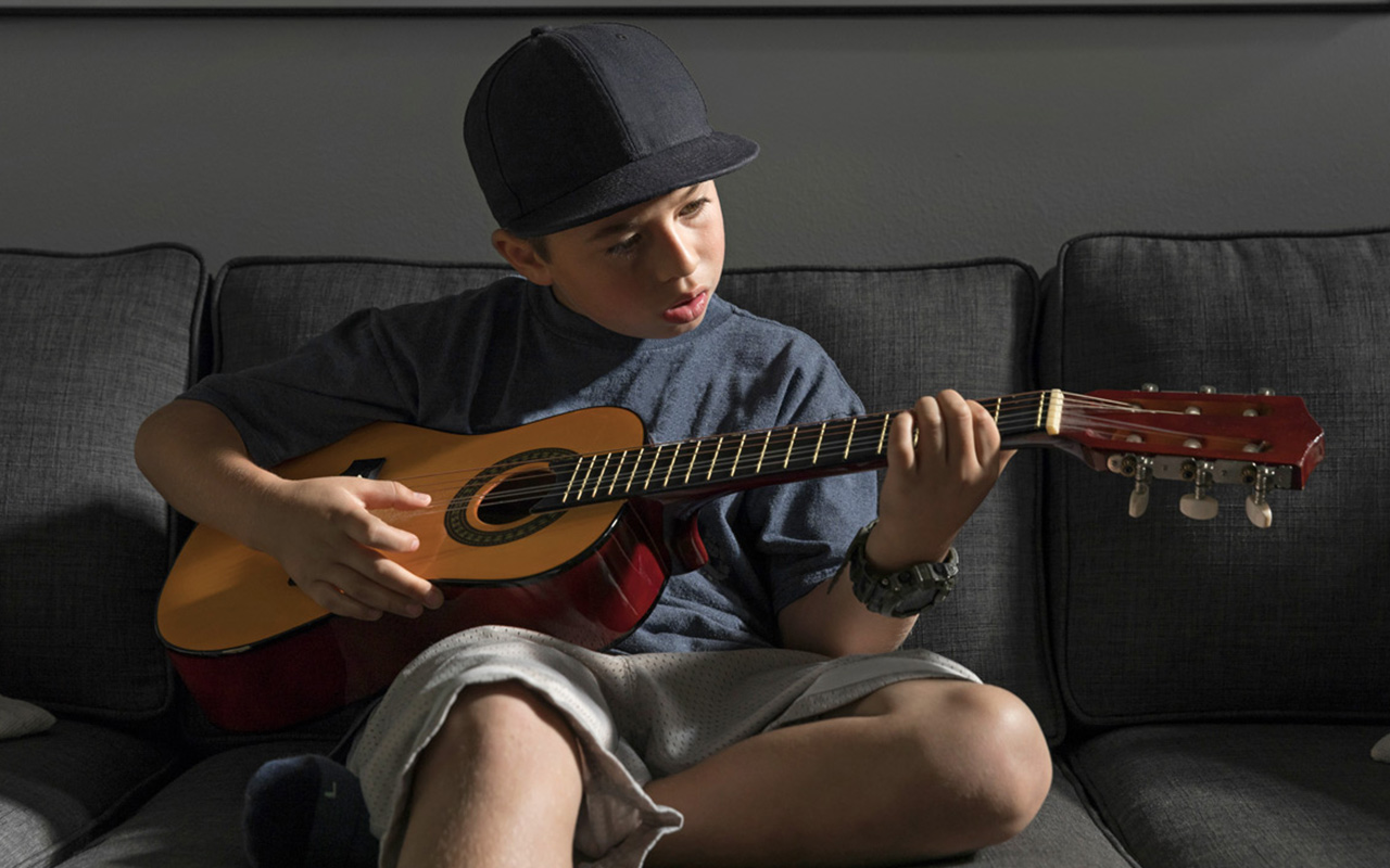 A kids plays guitar.