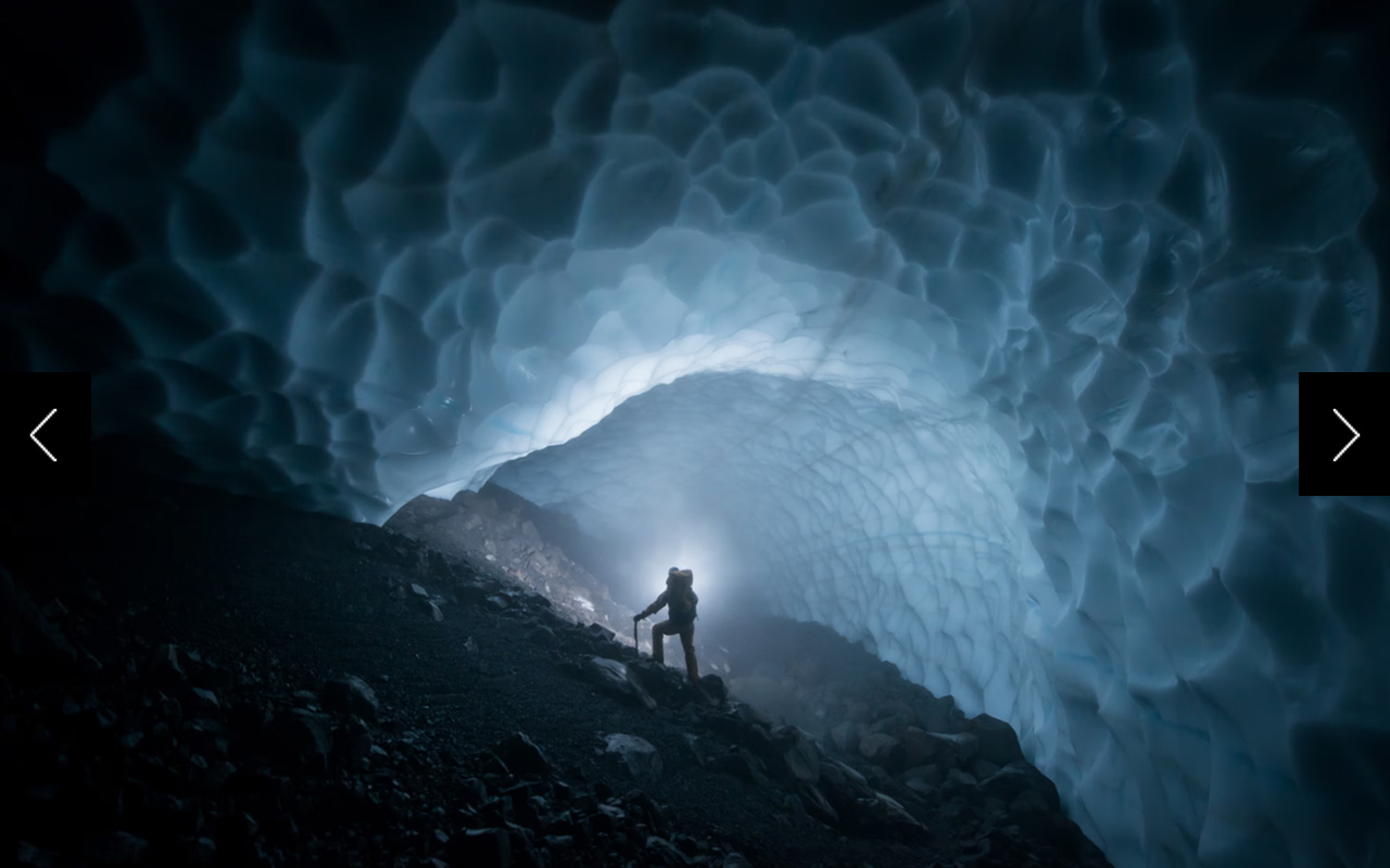 Tabby Cavendish, a ranger at Mount Rainier National Park, peers into an otherworldly cave of ice within the eastern crater of Mount Rainier.