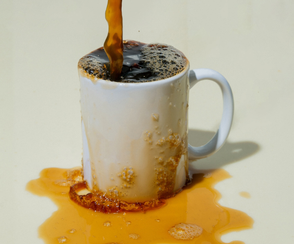 Coffee overflows in a white mug 