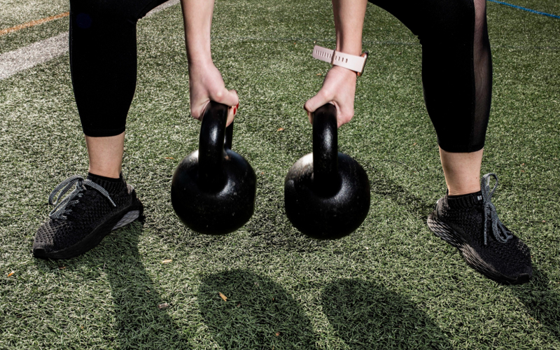 An individual holding kettlebells