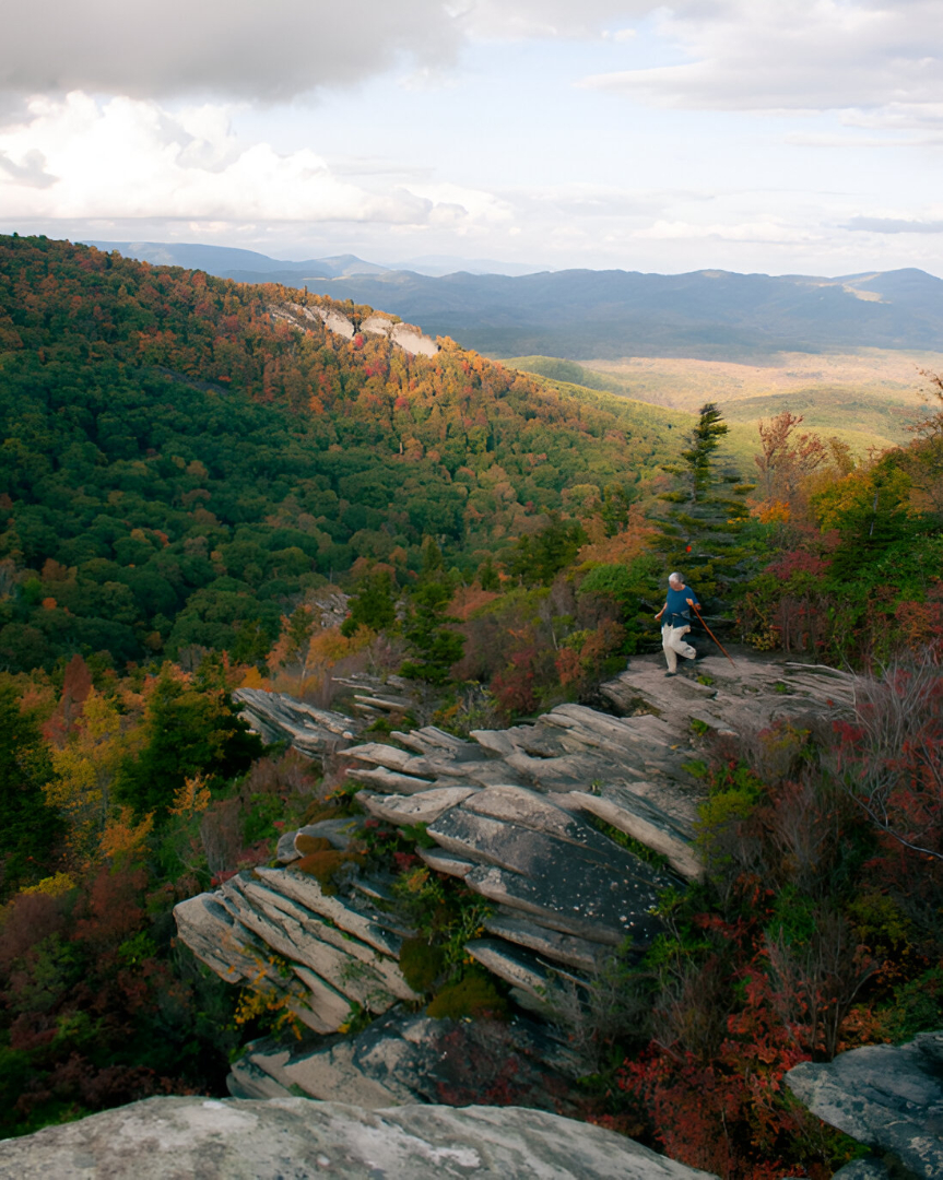 Ani mage of a hiker in mountains during fall foliage