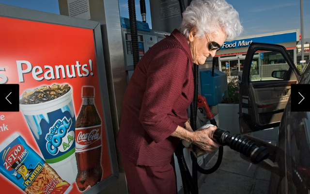 Marge Jetton, 100-year-old, fills up her car with gas at a gas station.  