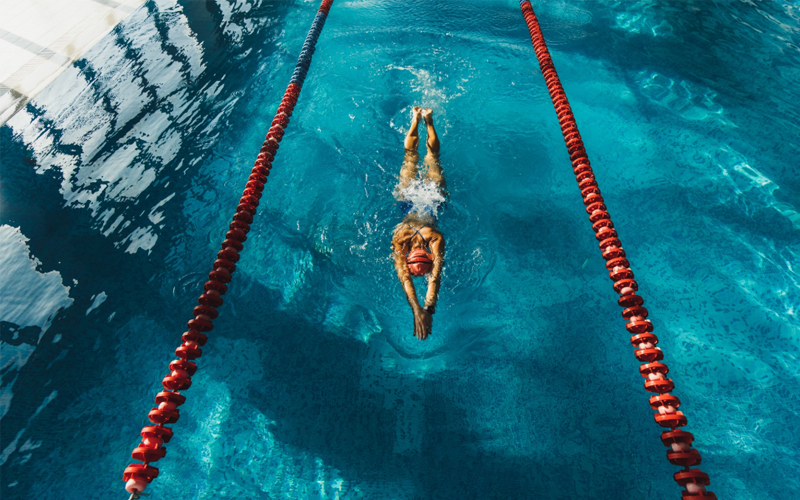 A woman swims in a pool lane