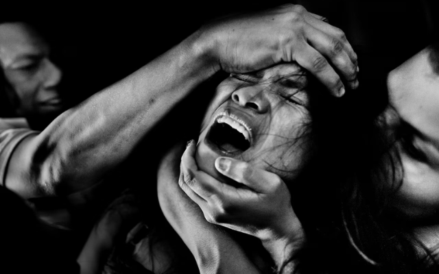 A Colombian girl screams from pain and fear while being allegedly possessed by demons during an exorcism ritual performed at a house church. 