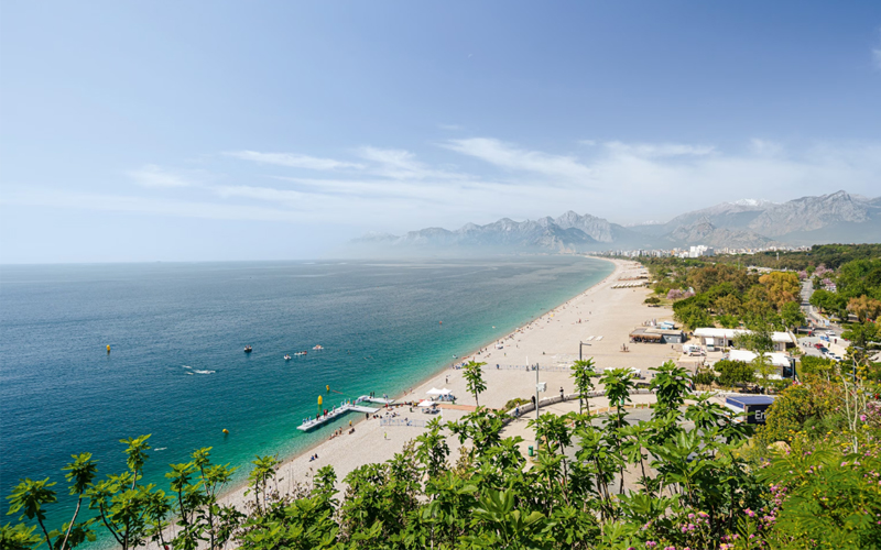 Konyaalti Beach Park is shaded by palm trees and popular with locals.