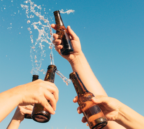People cheers with beer bottles.