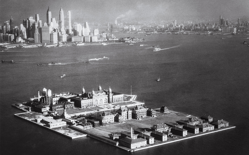 Black and white photo of an aerial view of Ellis Island. 