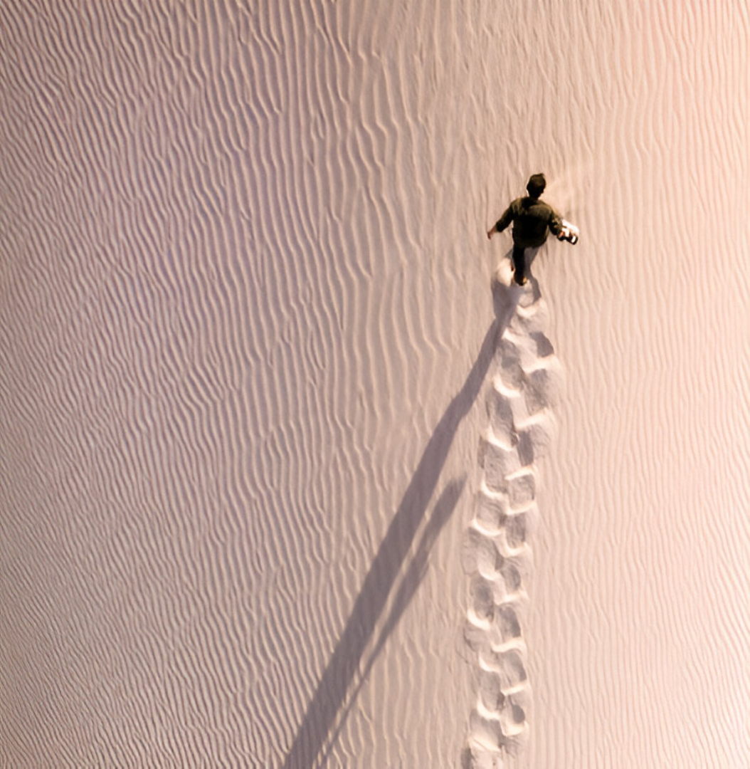 An explorer walks across sand dunes on Socotra, Yemen, 2018