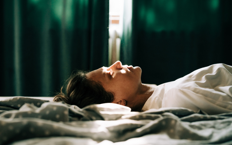 A woman lays in her bed