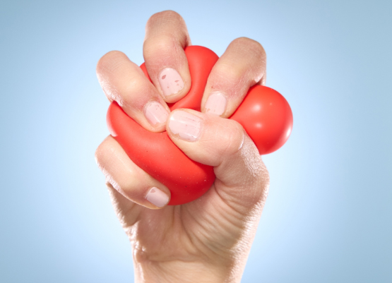 A hand grips a ball.
