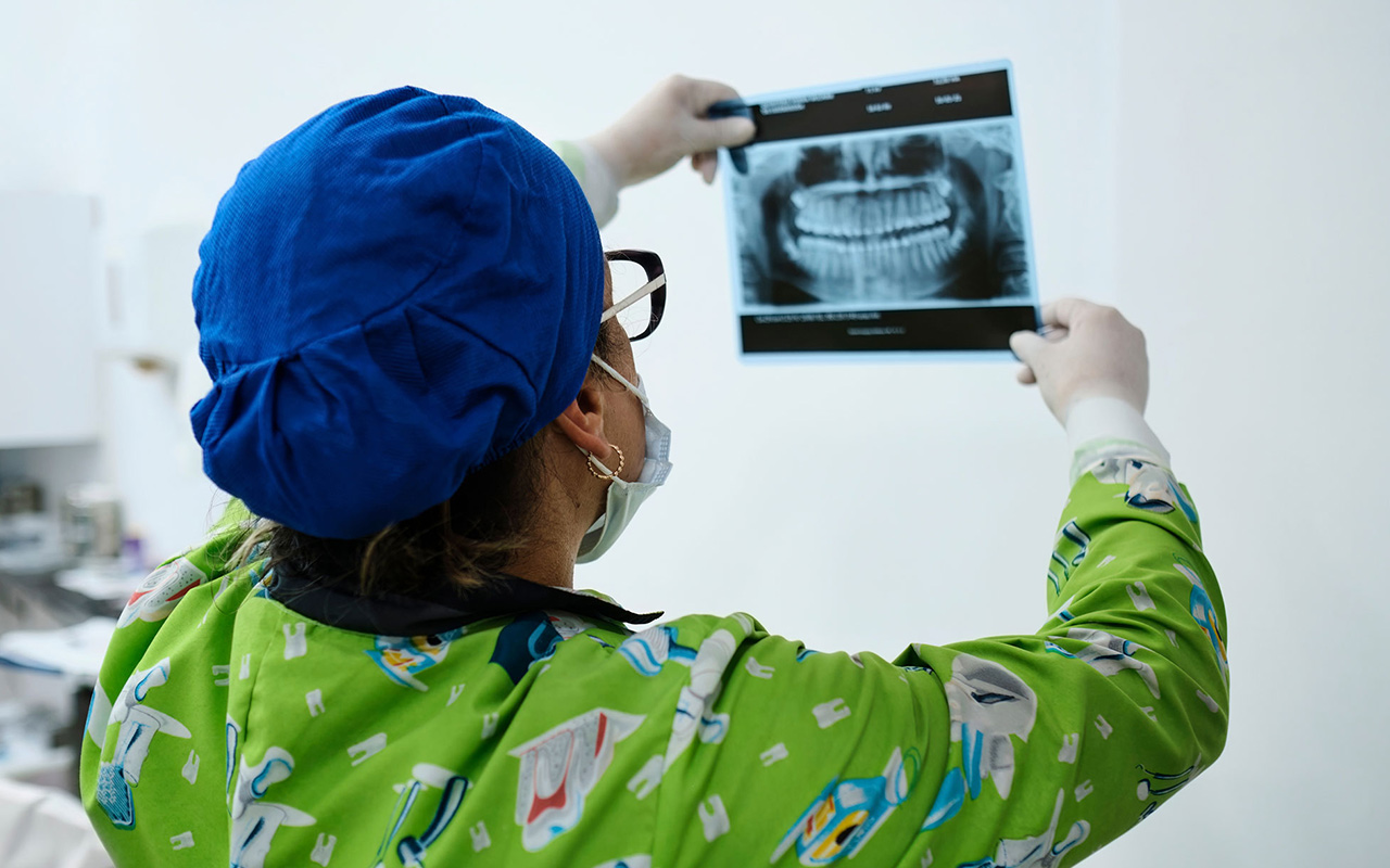 A dentist reviews a dental X-ray.