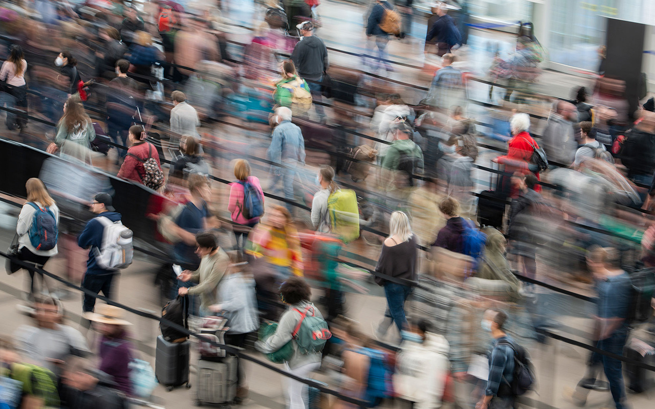 Lines of people are a blur at an airport.