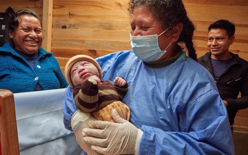 A midwife holds a newborn