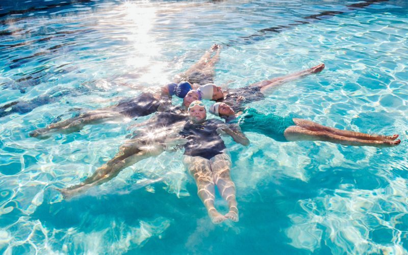 Members of a senior synchronized swimming team pose during practice.