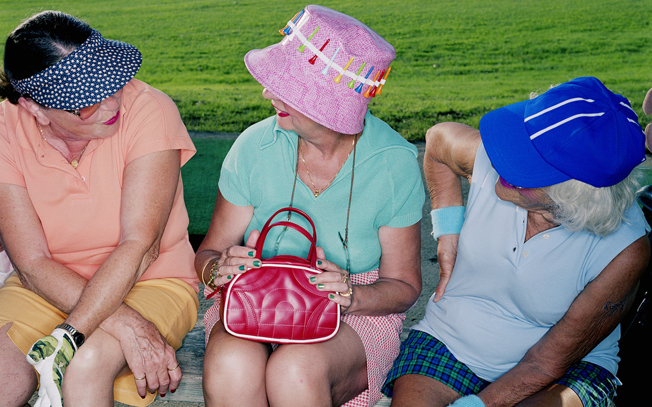 A group of women sit and talk on a bench